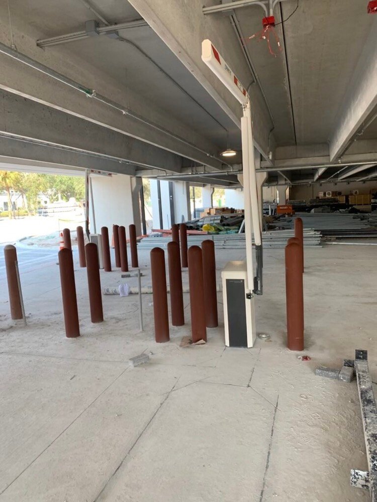 Protective bollards and lane control equipment installed at a parking garage entrance