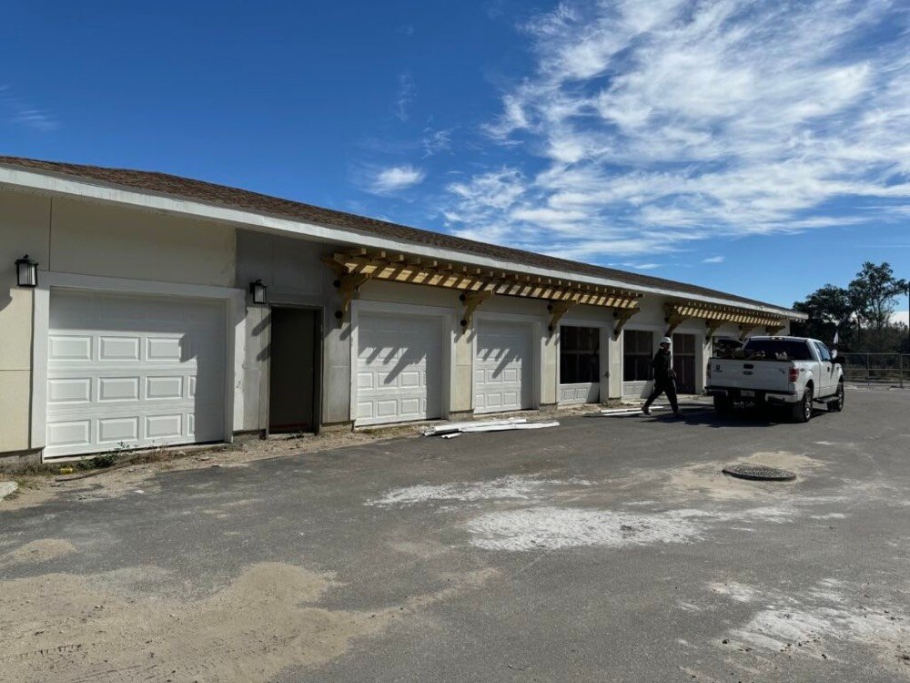 Newly installed sectional garage doors along a residential building elevation